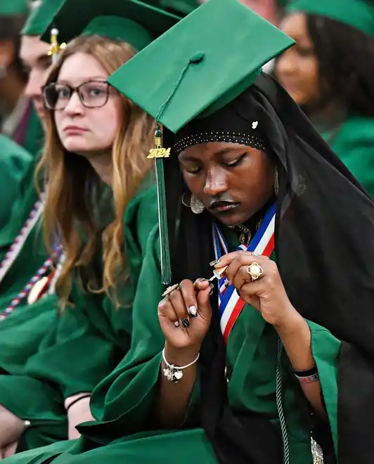 Israa Abdul-Rashid, front, adds a coat to her nails while waiting with fellow graduates, including Cayman Albright left, ahead of the York County School of Technology Graduation Ceremony at York Expo Center in West Manchester Township, Thursday, May 23, 2024. (Dawn J. Sagert/The York Dispatch)