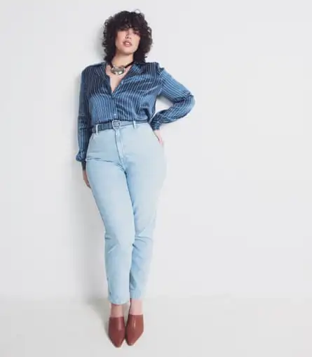 woman in high-waisted pale blue jeans with striped silk shirt