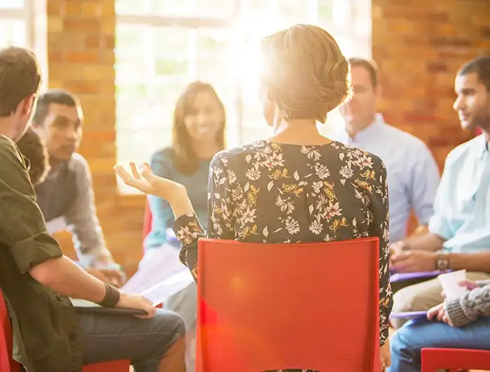 Charlotte Hungerford Hospital. Stock image of young adults seated in a group therapy circle talking