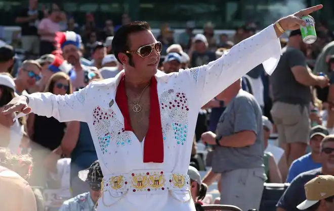 A man dressed as Elvis dances in the crowd, Saturday, Jan. 1, 2000, during Carb Day ahead of the 108th running of the Indianapolis 500 at Indianapolis Motor Speedway.