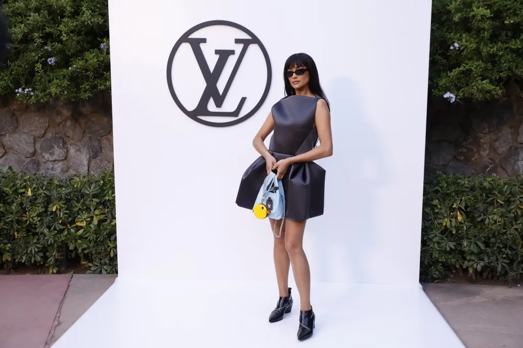 Shay Mitchell poses at the photocall of the Louis Vuitton fashion show at Park Guell in Barcelona wearing black ankle boots