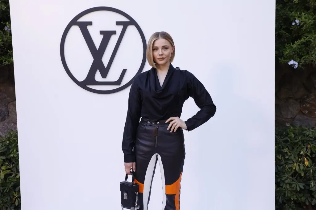 Chloe Grace Moretz poses at the photocall of the Louis Vuitton fashion show at Park Guell in Barcelona wearing black pointed toe shoes