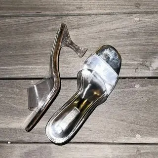 Clear sandals on a wood floor