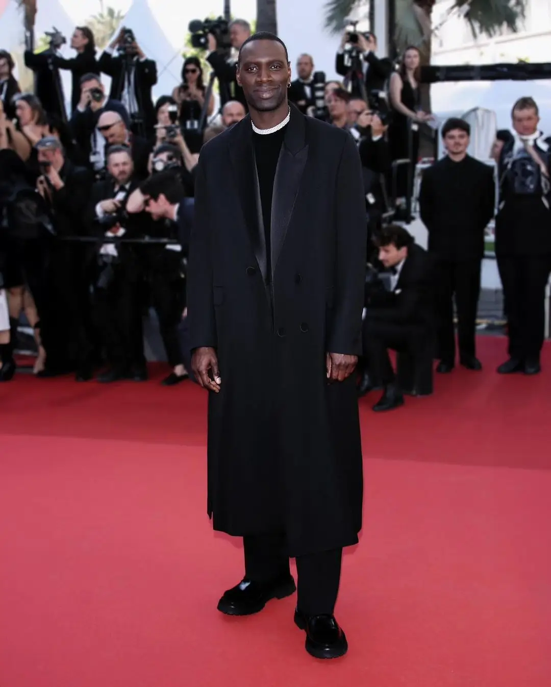 Omar Sy, actor and a member of the Cannes jury, epitomised Parisian chic in an Ami Paris trench coat, chunky loafers and a knit shirt with a white collar. Omar Sy, actor and a member of the Cannes jury, epitomised Parisian chic in an Ami Paris trench coat, chunky loafers and a knit shirt with a white collar.