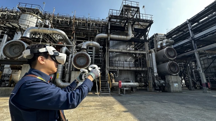 An　SK　Energy　employee　wearing　an　AR　headset　checks　the　condition　of　a　heating　system　at　SK　Innovation’s　Ulsan　Complex