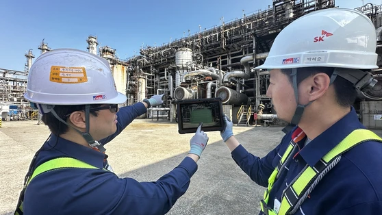 SK Innovation workers inspect the inside of a heat exchange virtually at the Ulsan Complex on Thursday. [SK INNOVATION]