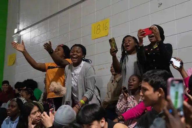 Students at Newcomer Academy cheer for their friends as they walk down the runway during the Newcomer Academy Fashion Show on Friday, April 19, 2024.