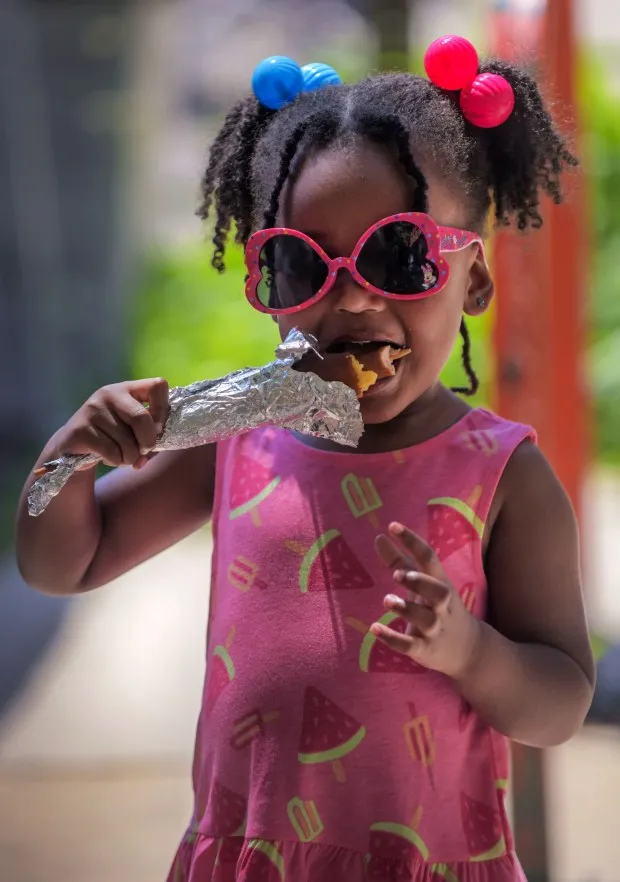 Soleil Winston, 3 of Bolton Hill eats with parents Dwayne Winston and Trevell Winston during the annual Sowebo arts and music festival around Hollins Market. (Karl Merton Ferron/Staff)