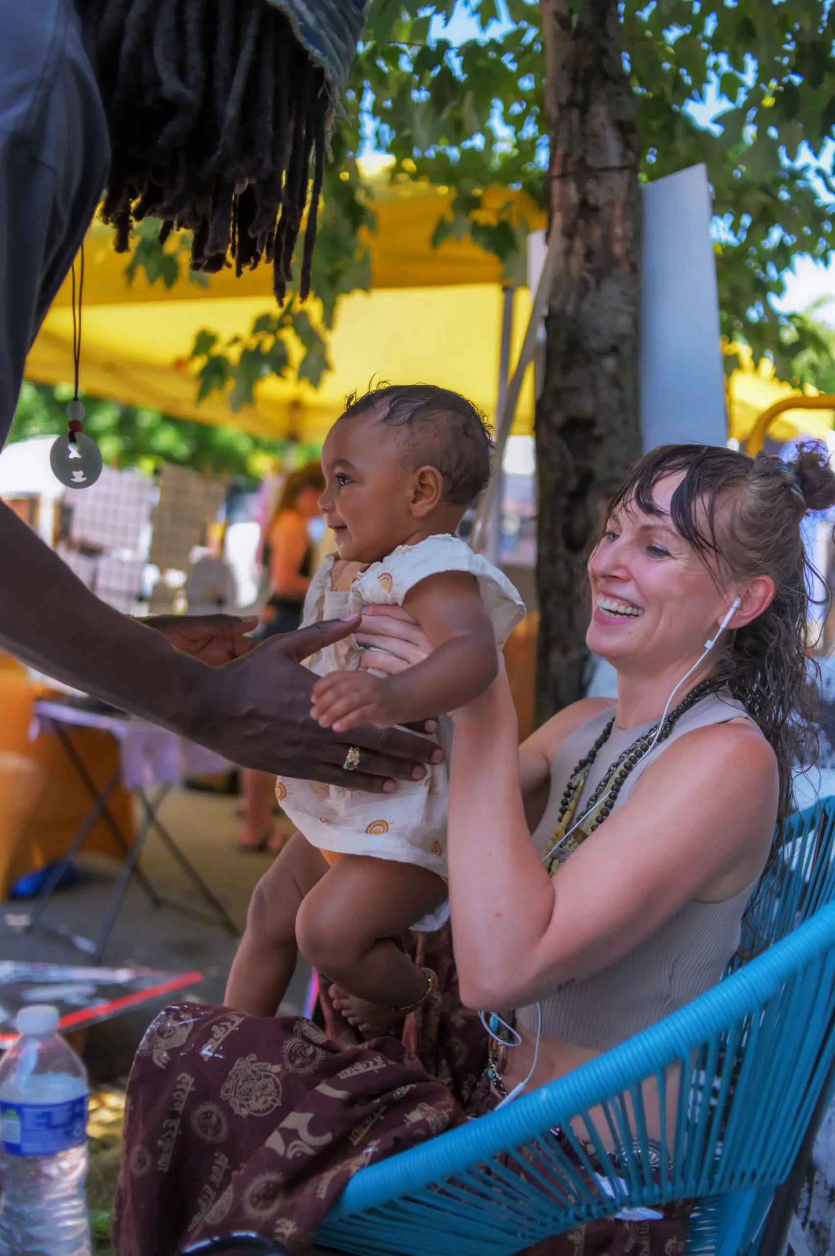 Malcolm Sykes of Hollins Market relieves his girlfriend Kim McCloskey of their eight month old child Sequoya Sykes during the annual Sowebo arts and music festival around Hollins Market. (Karl Merton Ferron/Staff)