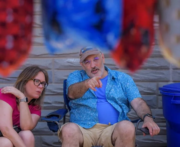 Jen Morales of Vienna, VA and Steve Corrozi Pigtoown stick to people watching while sitting in shade during the annual Sowebo arts and music festival around Hollins Market. (Karl Merton Ferron/Staff)