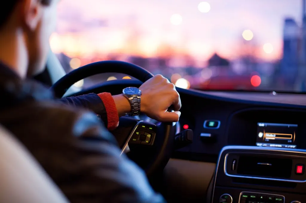 Driving a car at night - pretty, young woman driving her modern car