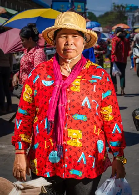 A woman in a bright blouse with LV on it