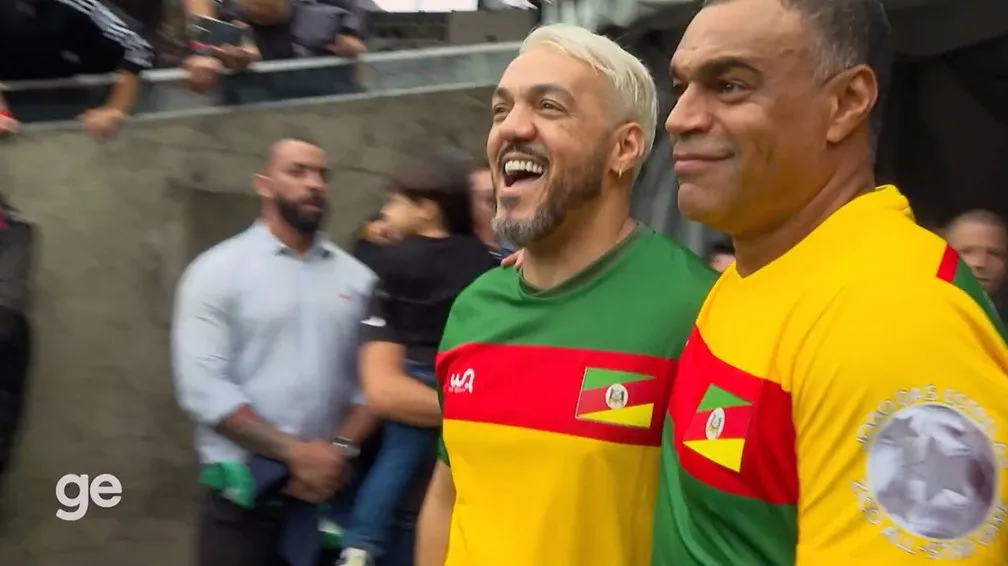 Belo e Denílson entraram abraçados em campo no Futebol Solidário — Foto: Reprodução/ge