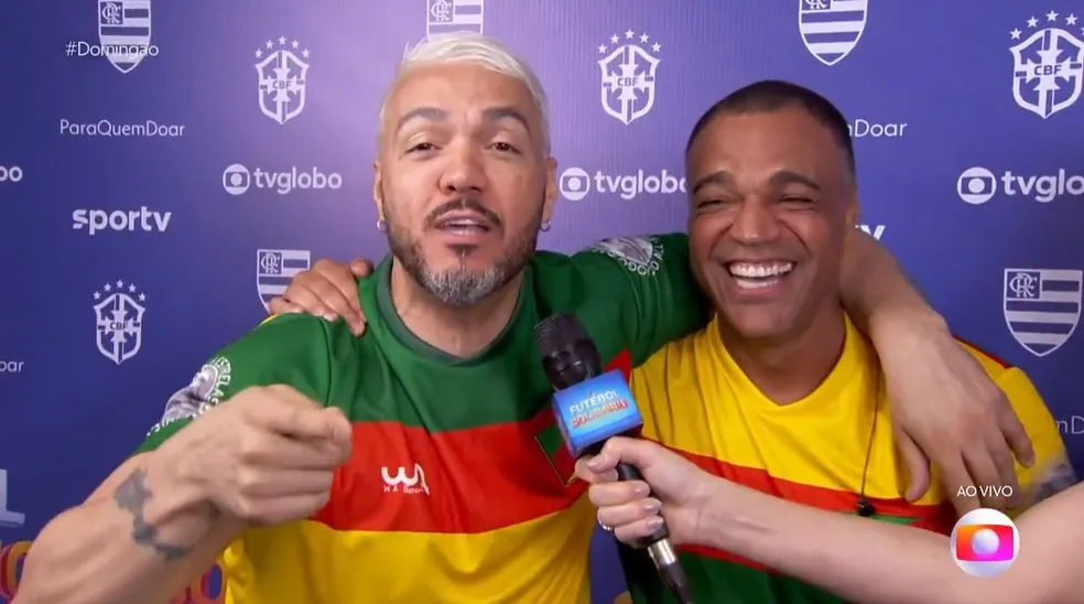 Belo e Denilson se abraçam antes da partida do Futebol Solidário — Foto: Reprodução/TV Globo