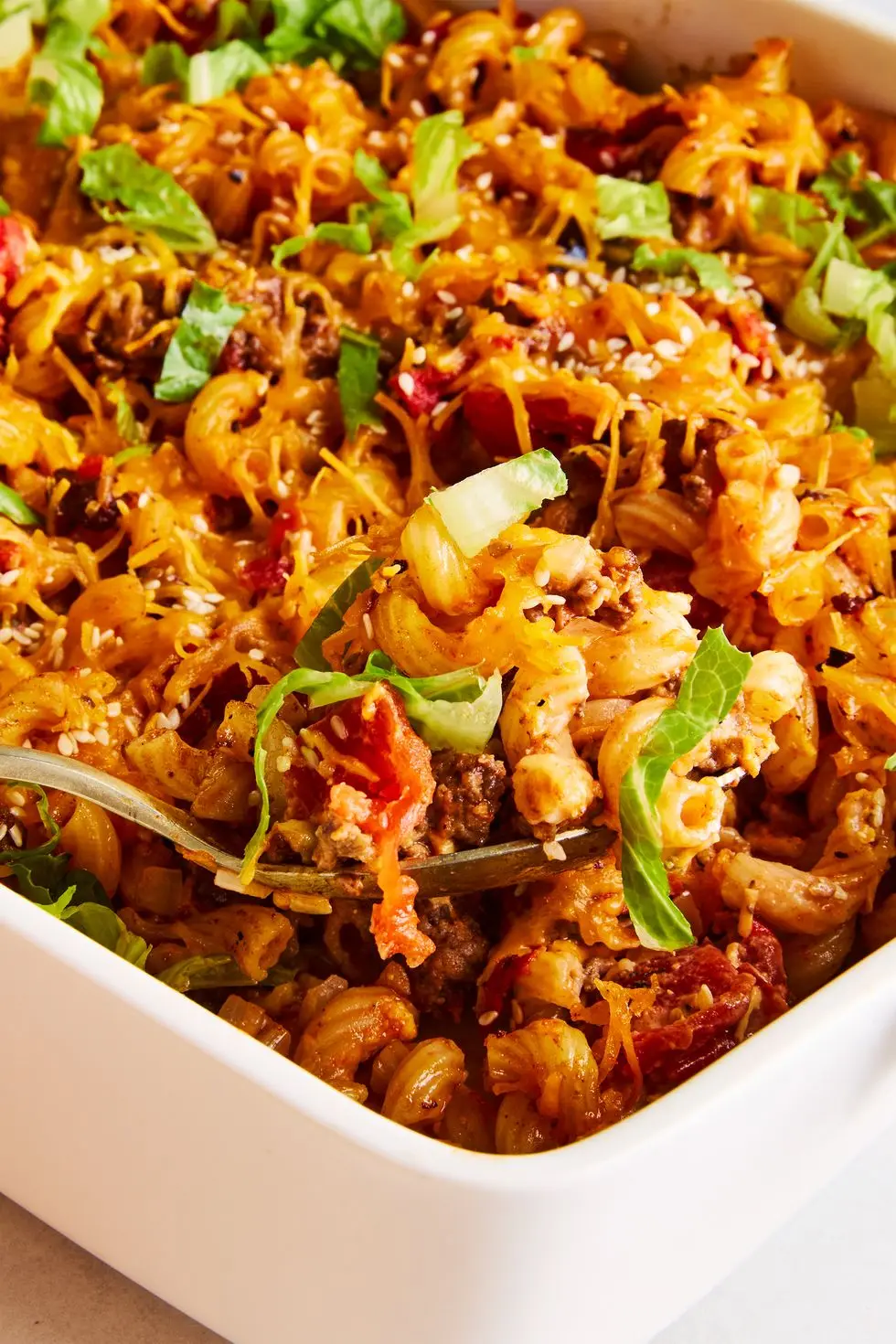 a casserole dish filled with elbow macaroni, ground beef, and a creamy sauce