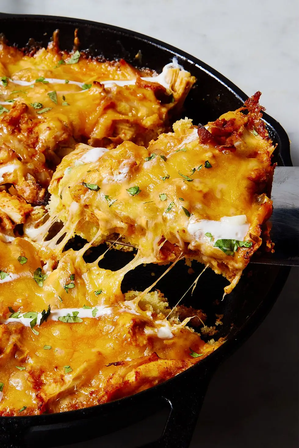 chicken tamale pie in a skillet with sour cream