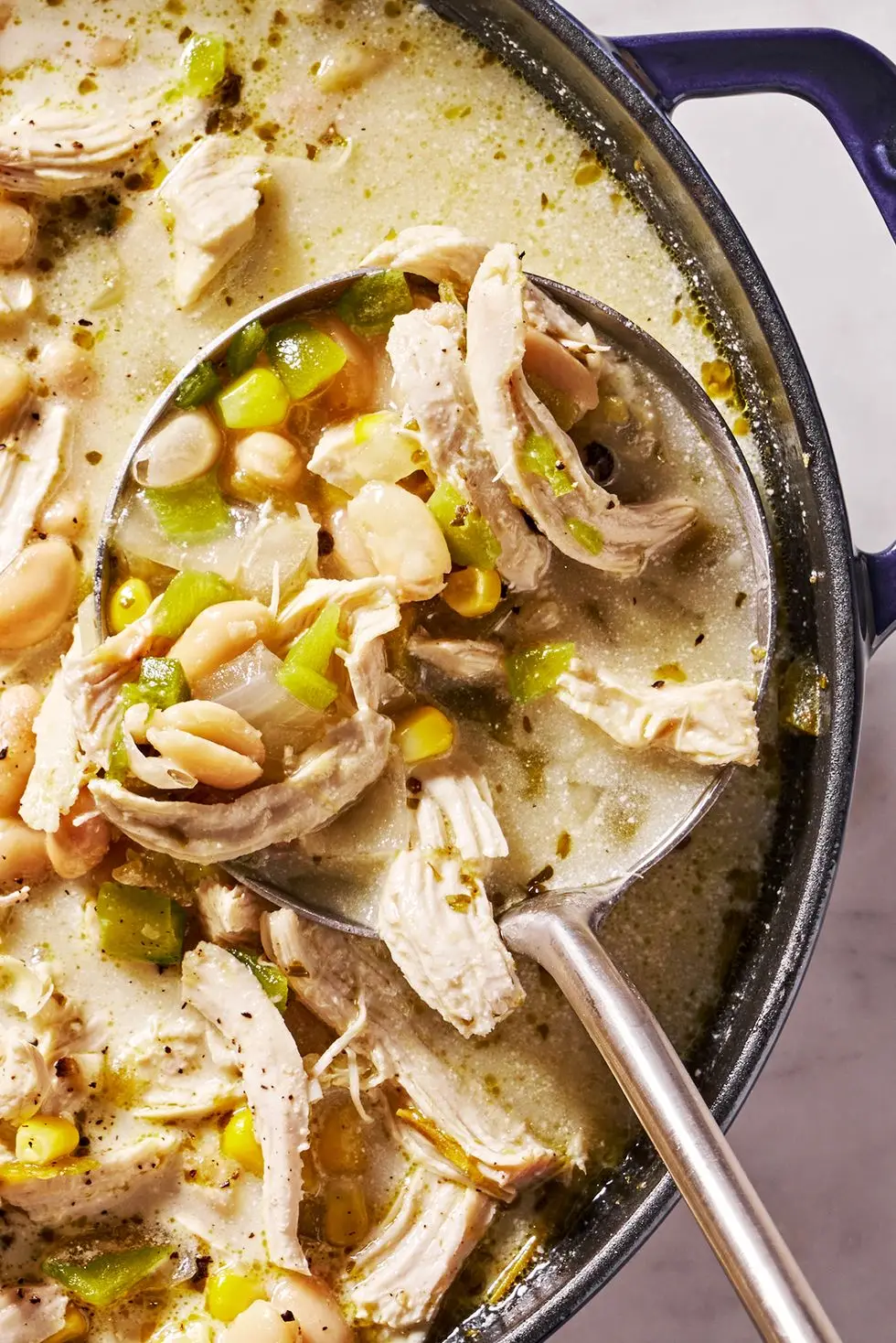 white chicken chili with cilantro, chips, sour cream and avocado