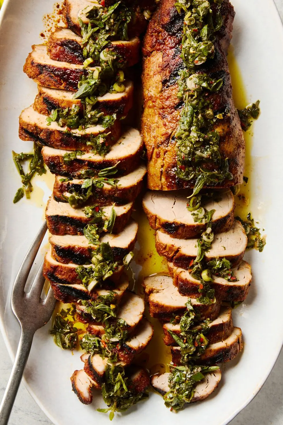 grilled pork tenderloin sliced and topped with a fresh herb sauce