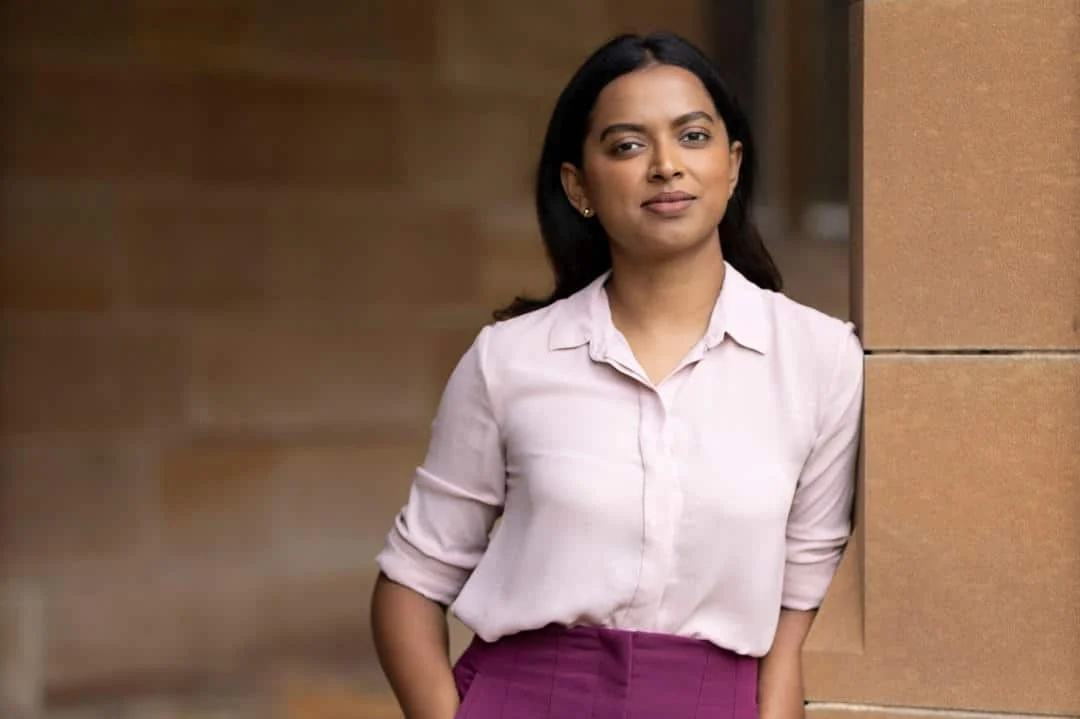 Astronomer leaning against sandstone wall