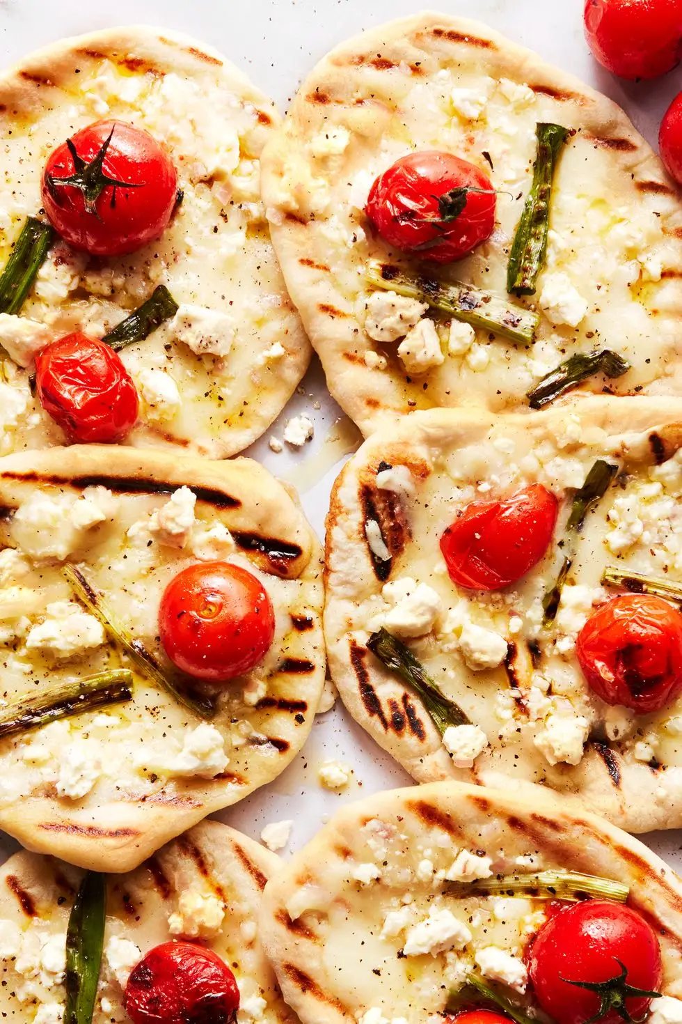 grilled tomato feta pizzettes with scallions and mozzaraella