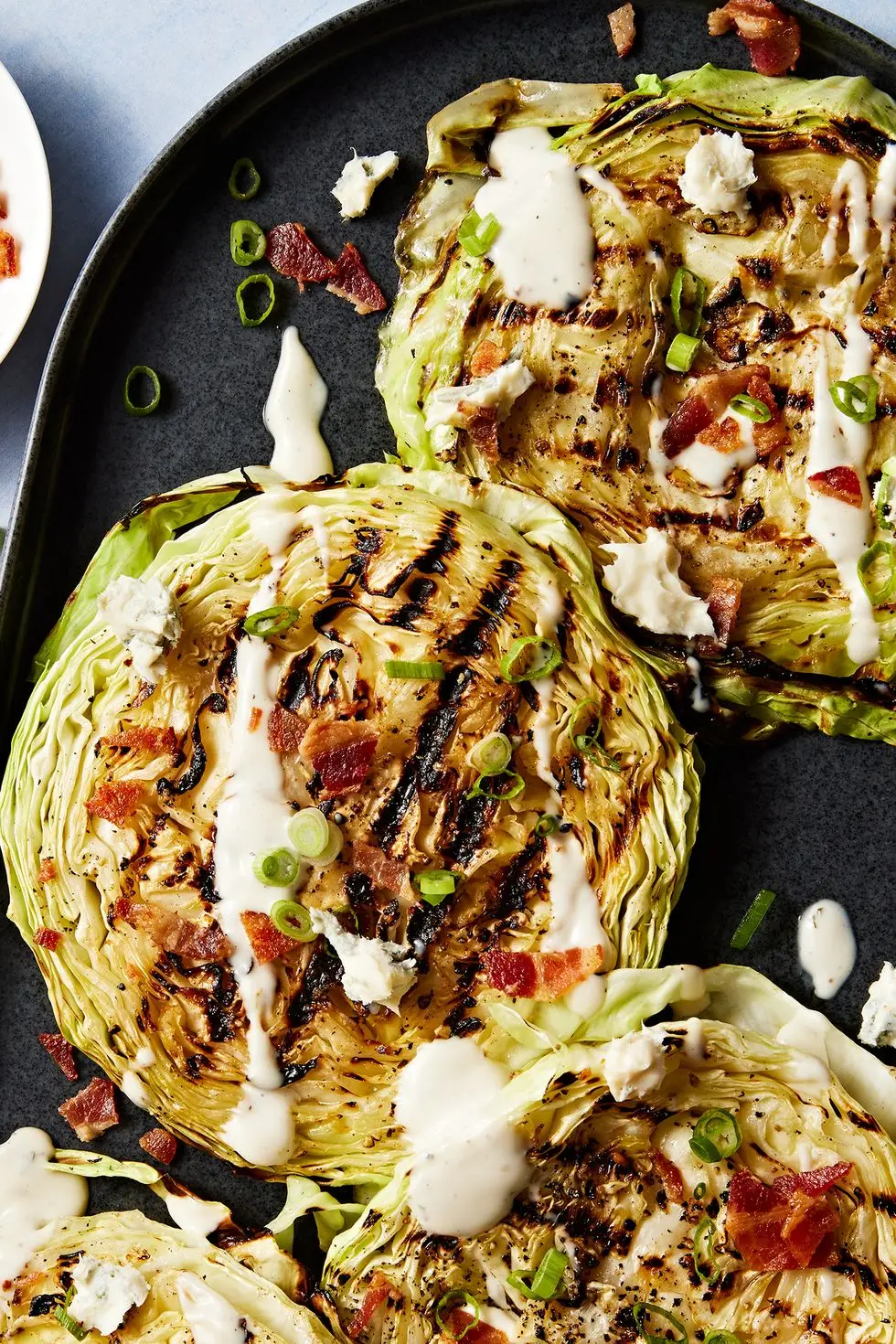 grilled cabbage steaks topped with bacon, sour cream and chives