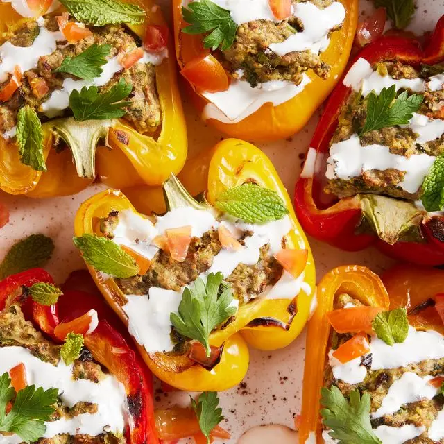 multicolored peppers stuffed with shawarma and drizzled with a cream sauce and mint