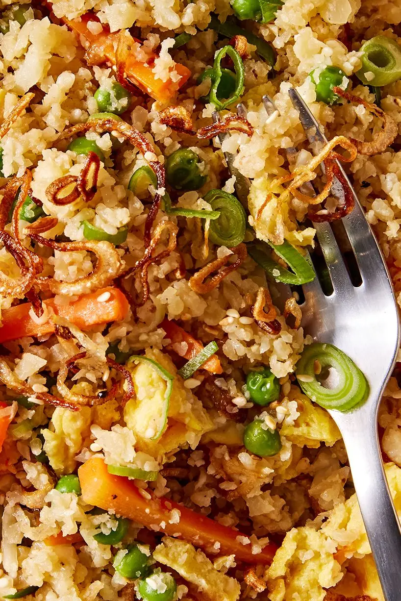 cauliflower fried rice with carrots, green onion, and eggs topped with sesame seeds