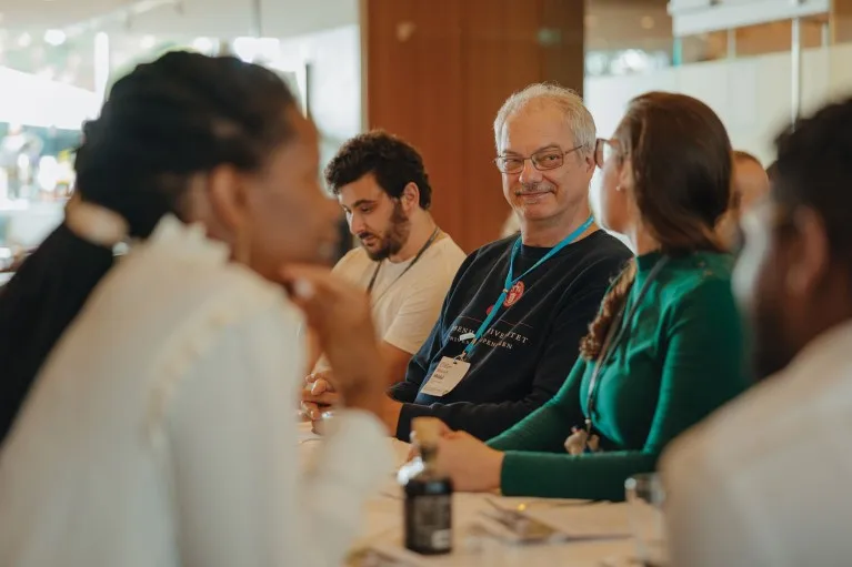 Nobel prize winner Morten Meldal sitting with a group of Young Scientist attendees of the 72nd Lindau Nobel Laureate Meeting