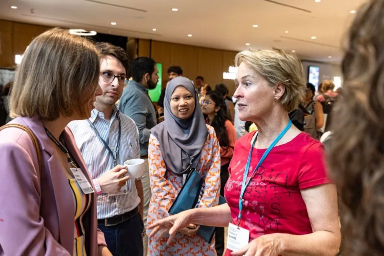 Nobel prize winner Frances Arnold standing with a group of Young Scientist attendees of the 72nd Lindau Nobel Laureate Meeting