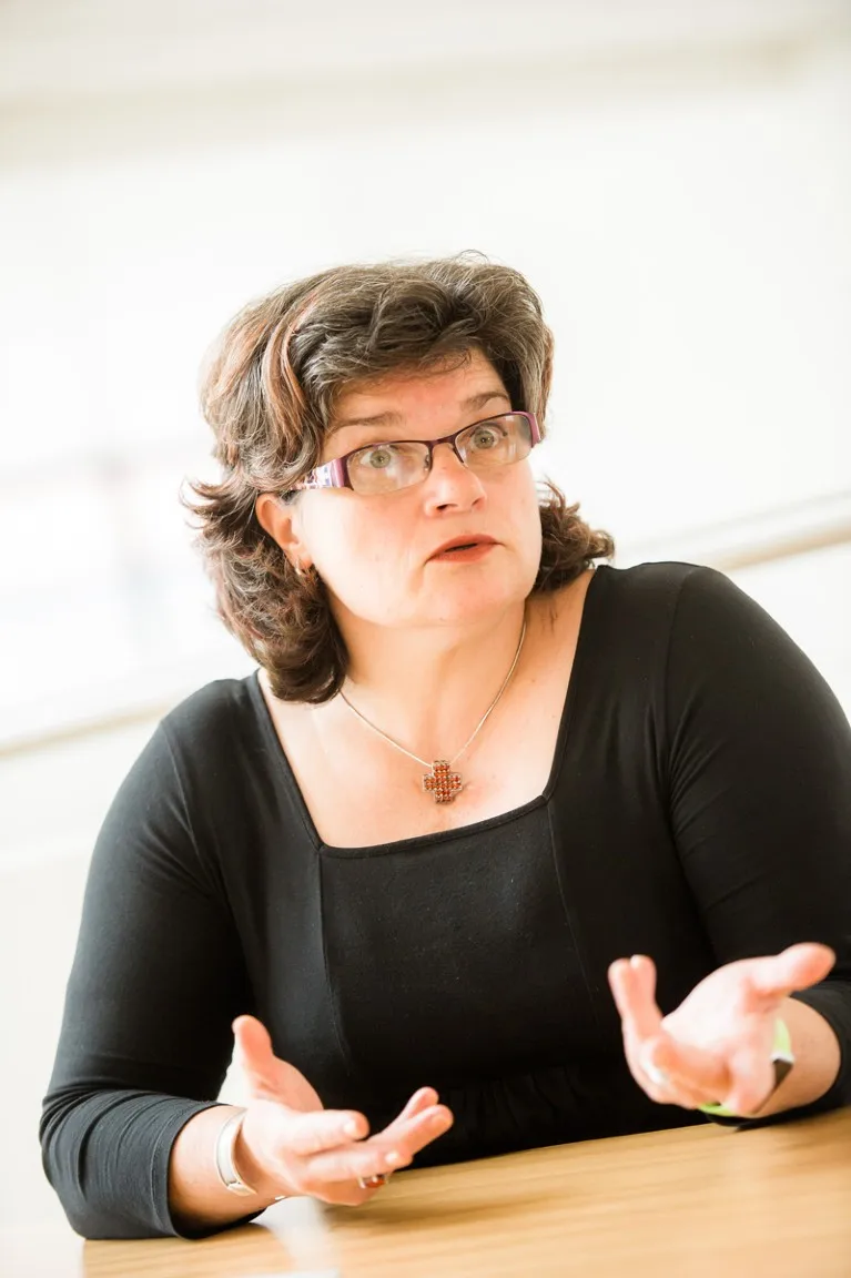 Maria Nedeva speaking while sitting at a table