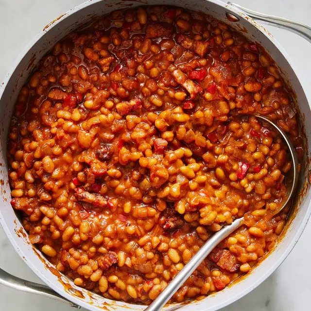 saucy baked beans scooped out of a pot