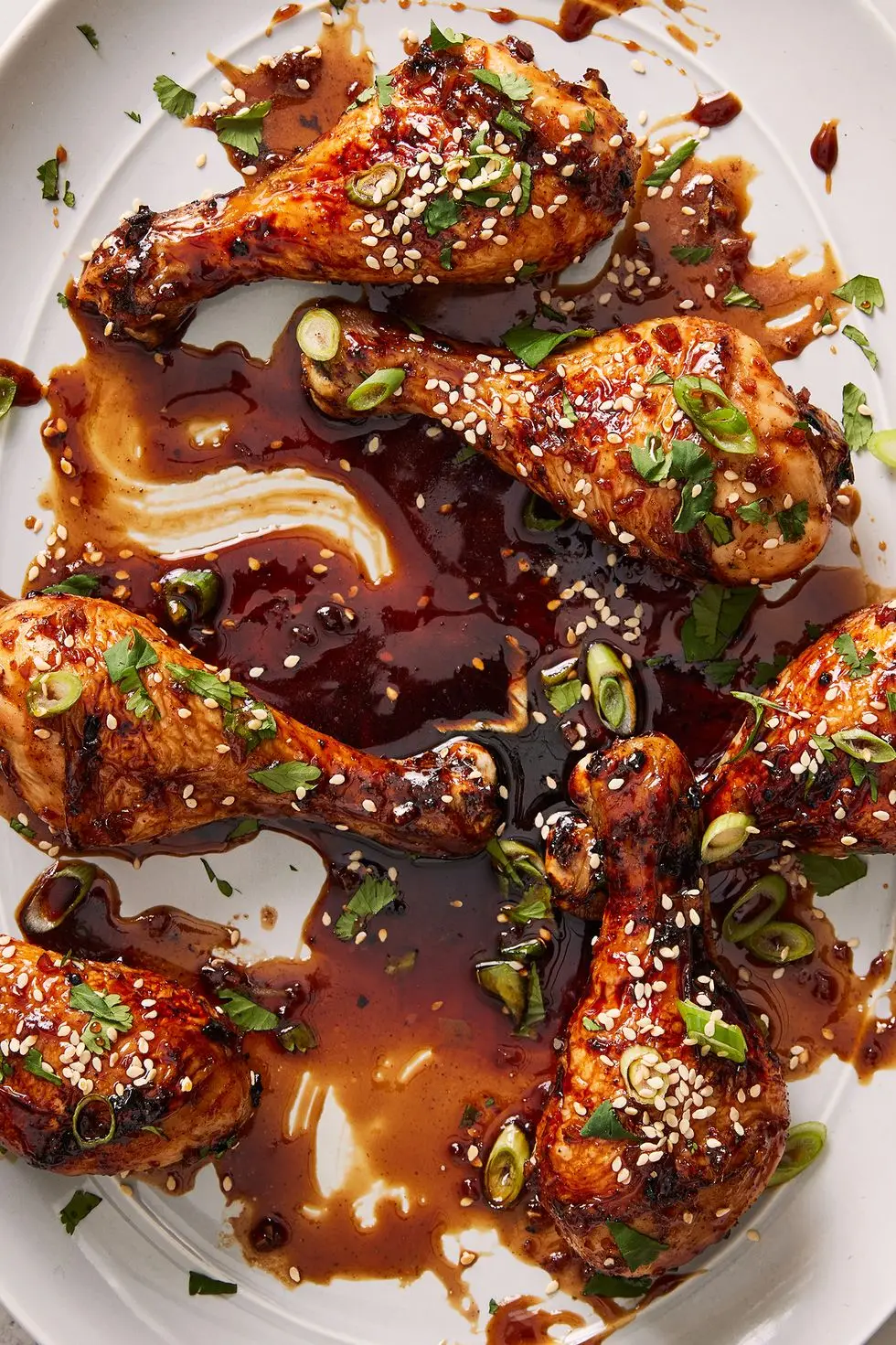 Air Fryer Drumsticks air fryer drumsticks coated in a soy, coca cola sauce topped with sesame seeds
