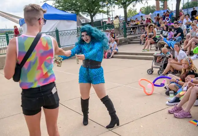 A drag performer adds to her handfuls of cash with a tip from a fan during a show at the River City Pride Festival on Saturday, July 20, 2024 on the Peoria riverfront.