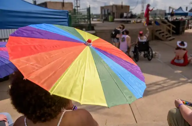 A rainbow umbrella shields a spectator from the sun during the Drag Wars show at the River City Pride Festival on Saturday, July 20, 2024 on the Peoria riverfront.