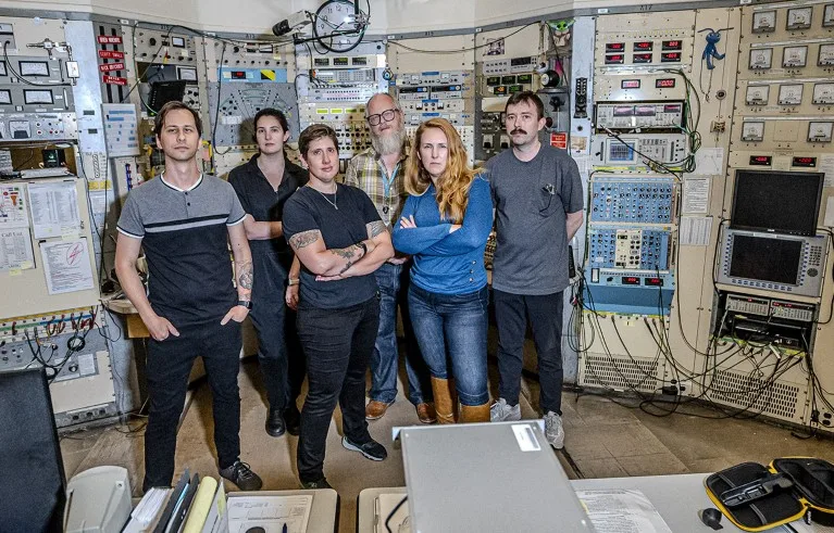 Erich Leistenschneider, Marilena Lykiardopoulou, Jacklyn Gates, Rod Clark, Jenn Pore, and Rodney Orford pose for a photograph in the Building 88 control room of the Lawrence Berkeley National Laboratory.