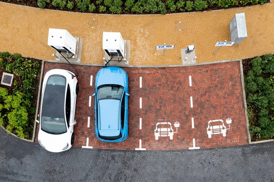 Overhead shot of two electric cars at EV charging stations.