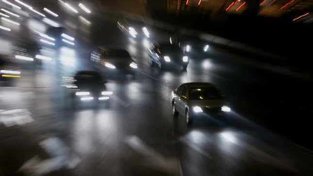 A photo of car headlights at night. 