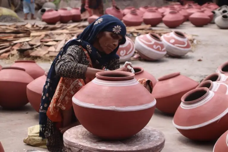 A woman decorating the pots for sale in Ranapur village. Image by Aishwarya Mohanty for Mongabay.