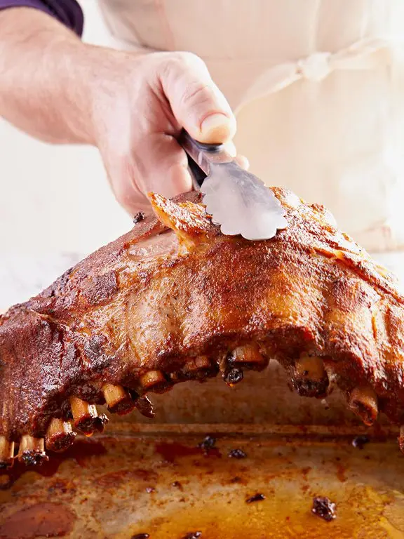 Pork Rib Doneness Test: U Shape. Lifting rack of ribs with tongs