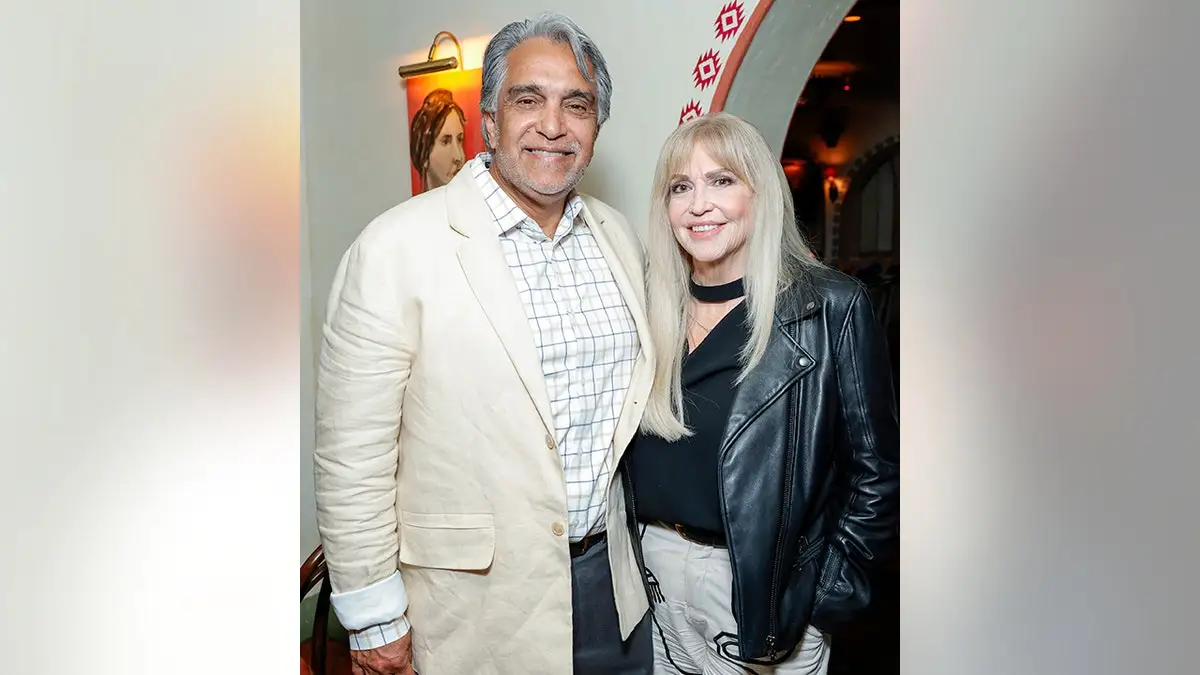 Jessica Alba's father Mark in a cream jacket and mother Catherine in a black leather jacket