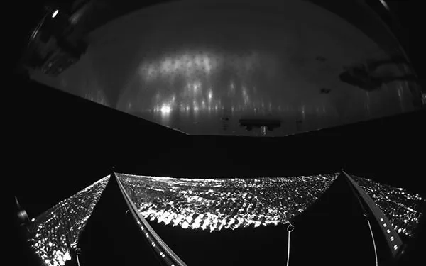 The Advanced Composite Solar Sail System has four black-and-white wide-angle cameras, centrally located aboard the spacecraft. Near the bottom of the photo, the view from one camera shows the reflective sail quadrants supported by composite booms.