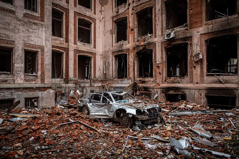 A wreckage of a silver car lies at the ruins of a university building located in centre of Kharkiv