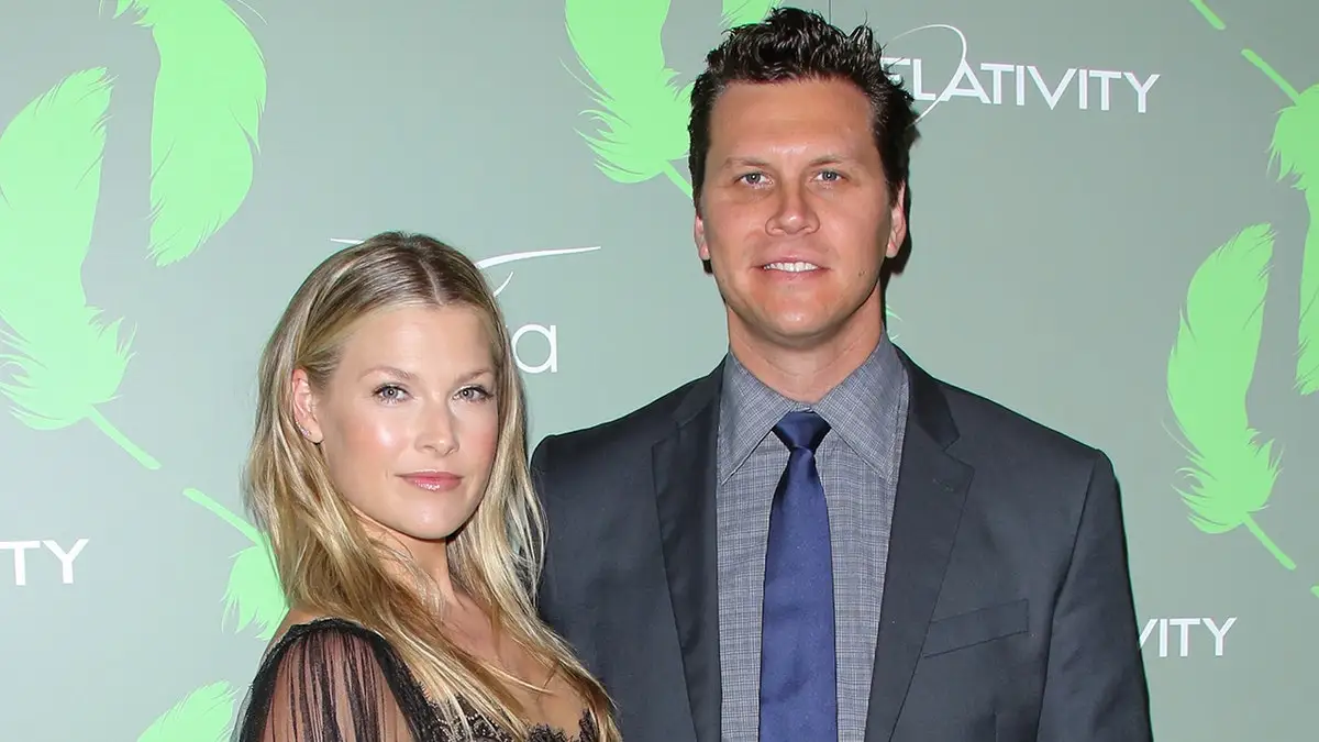 Ali Larter in a black lace dress poses with husband Hayes MacArthur in a dark grey/blue suit