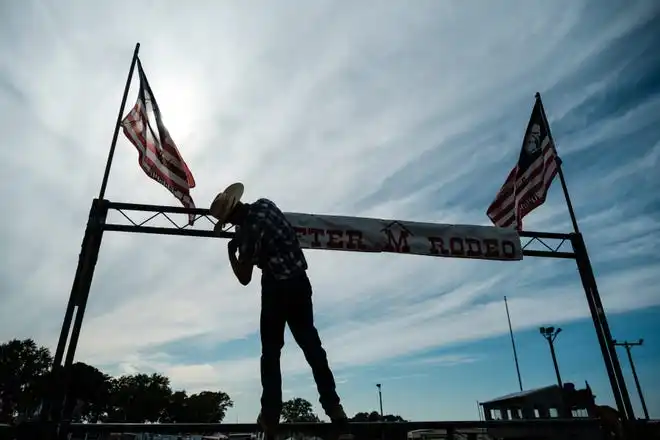 A banner is hung as preparations are made for the beginning of Rafter M Rodeo events at the Tuscarawas County Fair.