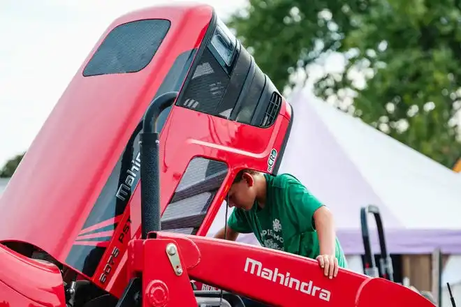 Deacon Dreher, 11, of Strasburg, inspects the engine of a piece of farm equipment on display at the Tuscarawas County Fair.