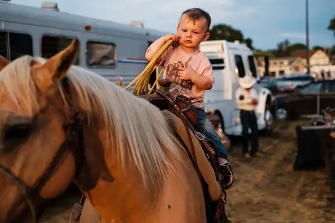 Tucker Treharne, 2, of Negley, sits atop his mom's horse before the start of rodeo events at the Tuscarawas County Fair.