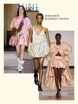 Left to right: A woman at Marques Alemeida wears a pink mini bubble hem dress with a brown crossbody bag. A woman at JW Anderson wears a ivory bubble hem dress with black boots. A woman at Simone Rocha wears a champagne colored long blouse and bubble hem skirt.