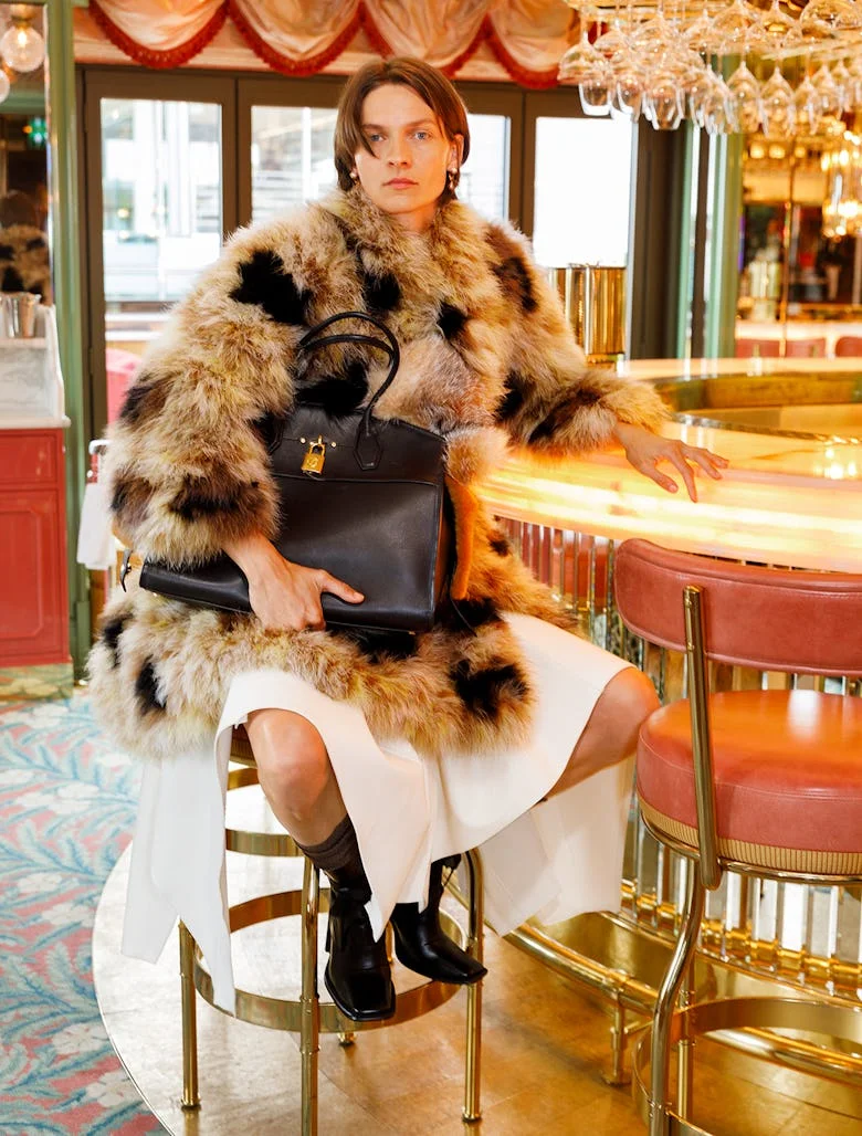 Woman at a cafe with furry coat and bag