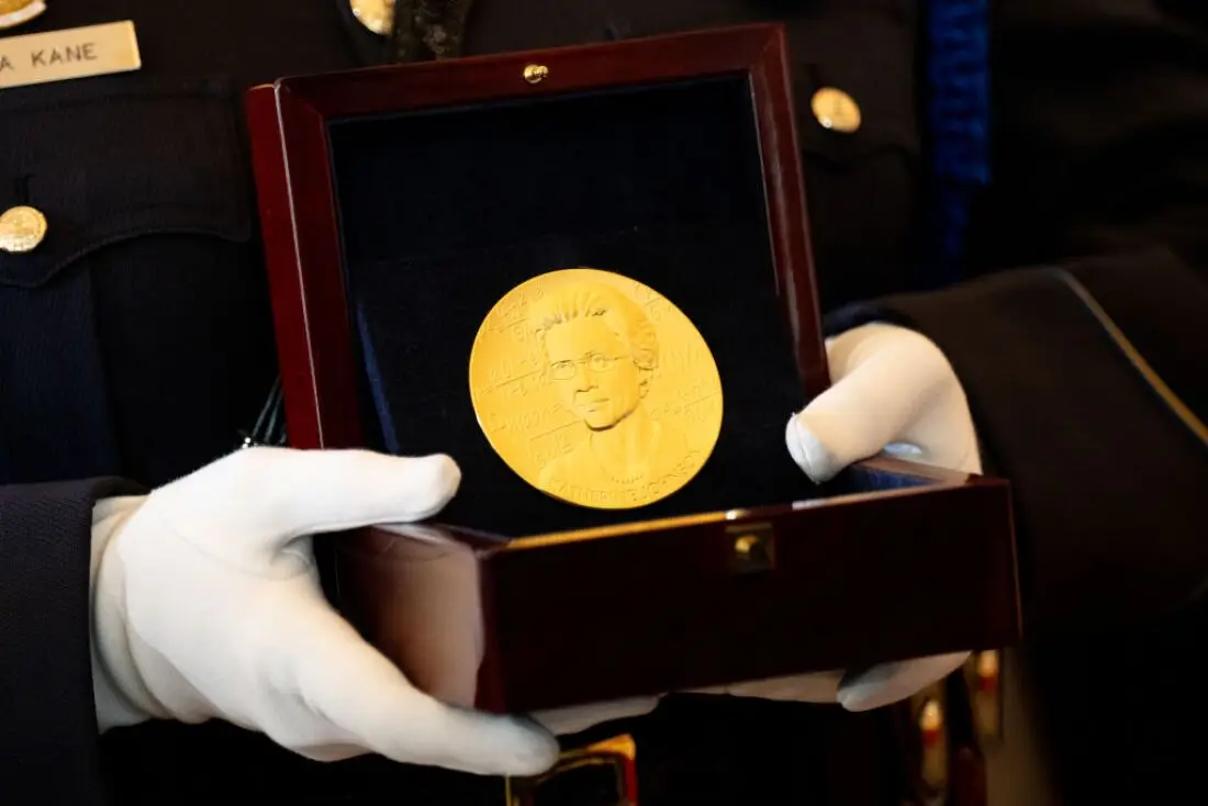 A member of the U.S. Capitol Police carries a Congressional Gold Medal for Katherine Johnson, one of NASA's 