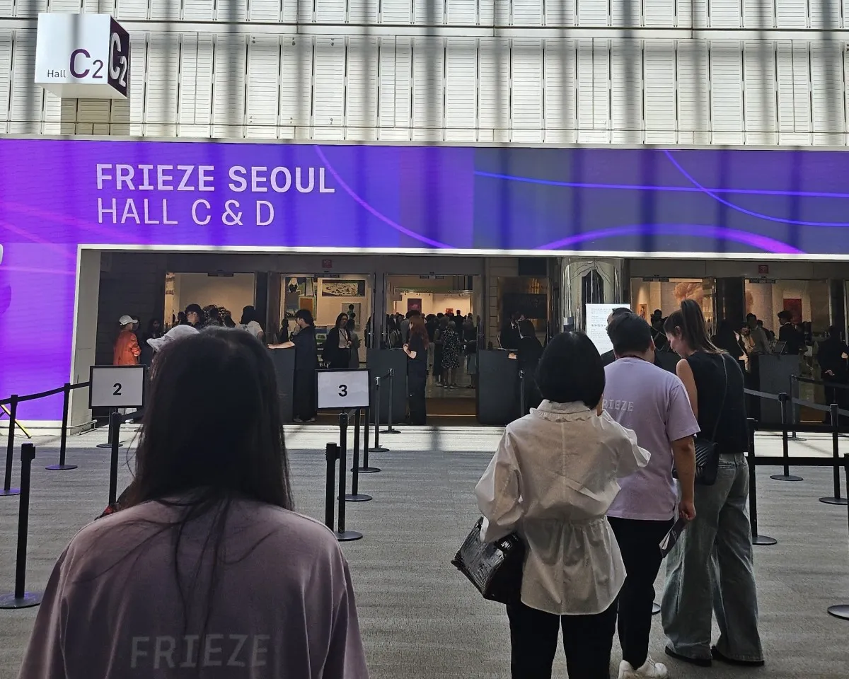 the backs of several people queuing to get into the Frieze Seoul art fair.